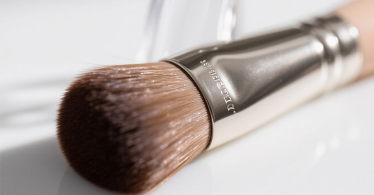 Flat foundation brush blending product on skin