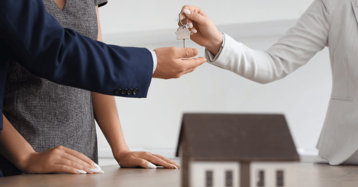 Estate agent handing over keys to new owners