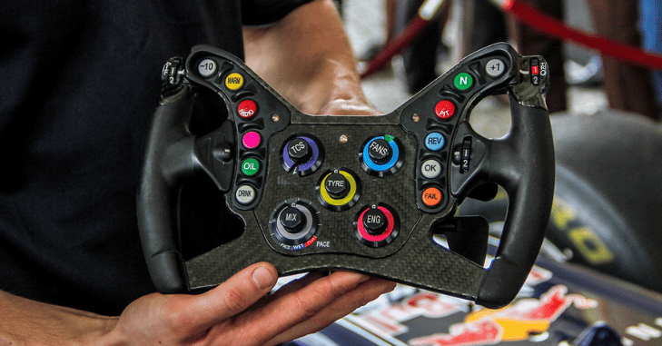 Driver gripping the wheel inside a racing cockpit